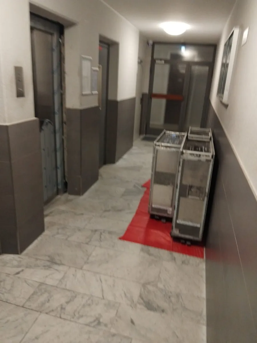 Rollcontainer mit Prüfgewichten vor einer Aufzugsanlage
